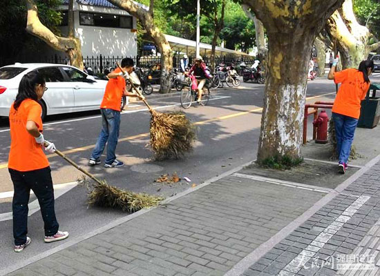 志愿者幫助環衛工人清掃馬路。